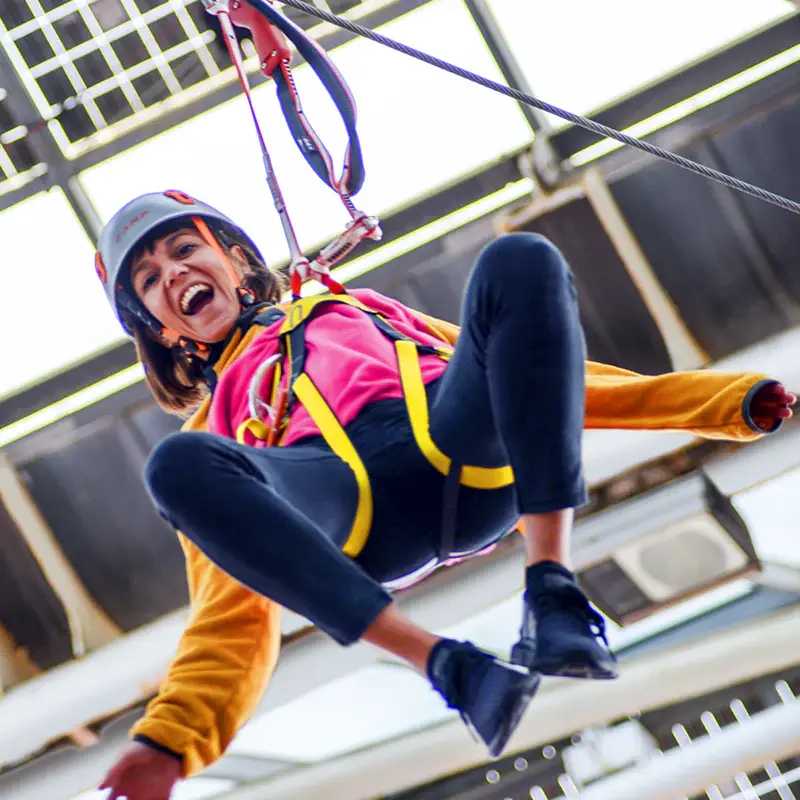 noia saltant tirolina al barcelona bosc urbà
