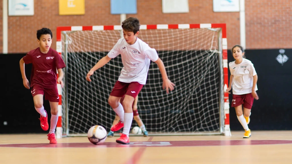 Nen samarreta blanca CET10 jugant a futbol sala al pavelló